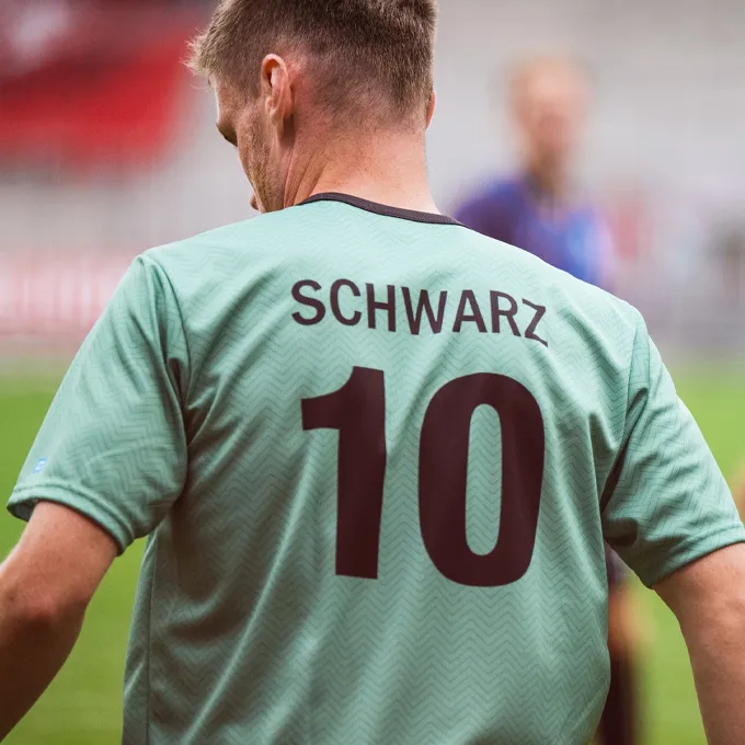 Een speler draagt een mintgroen voetbalshirt met het nummer 10 en de naam 'SCHWARZ' op de rug.