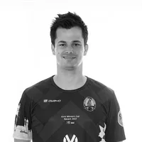 Een man draagt een aangepast zwart-wit sportshirt met een geometrisch patroon, het owayo-logo, een clubembleem en de tekst 'Euro Winners Cup Nazaré 2022'.