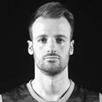 Een man in een donker, sportief V-hals shirt, dat aansluitende sportkleding vertegenwoordigt.