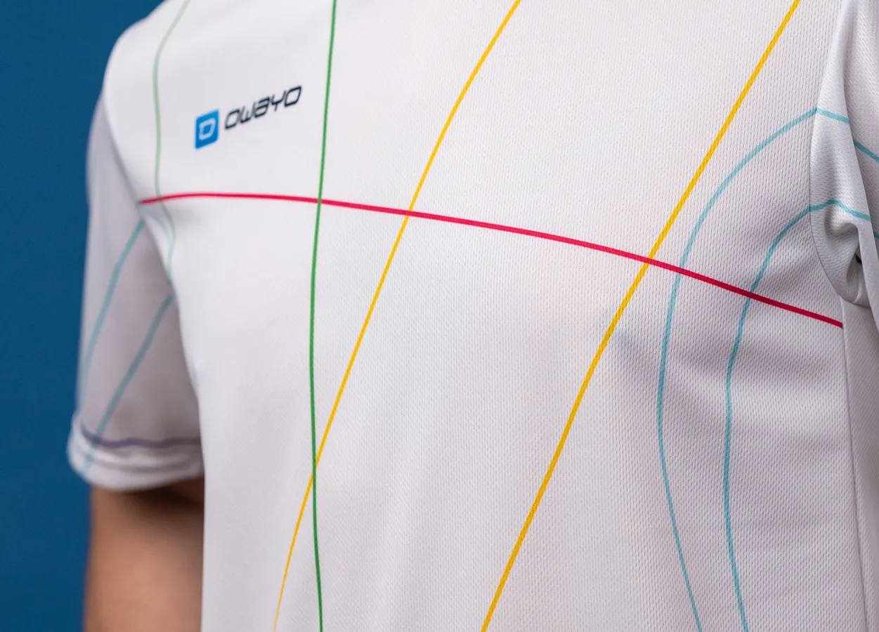 Een close-up van een wit sportshirt met kleurrijke lijnen in rood, geel, groen en blauw.