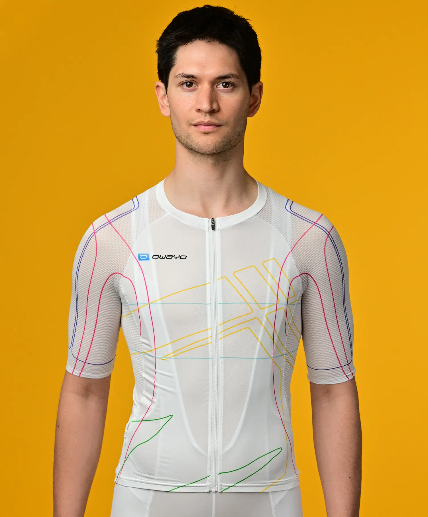 Een man draagt een wit, korte mouwen, sportshirt met kleurrijke lijnen van owayo tegen een gele achtergrond.