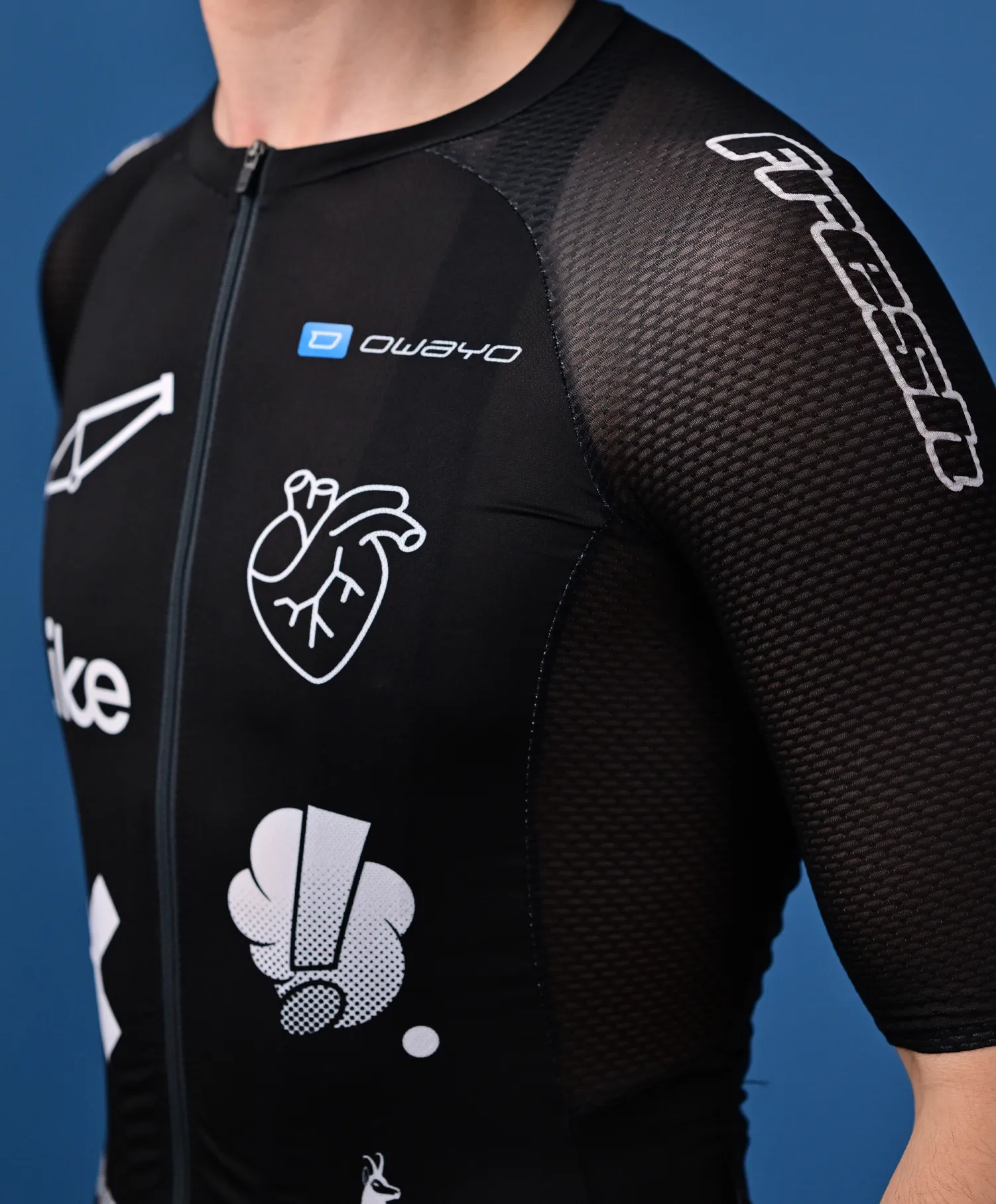 Een persoon draagt een zwart, mouwloos sportshirt van owayo met een rits aan de voorkant, versierd met diverse witte logo's en grafieken, waaronder een hart en een gestileerd 'O', op de borst en de mouw.