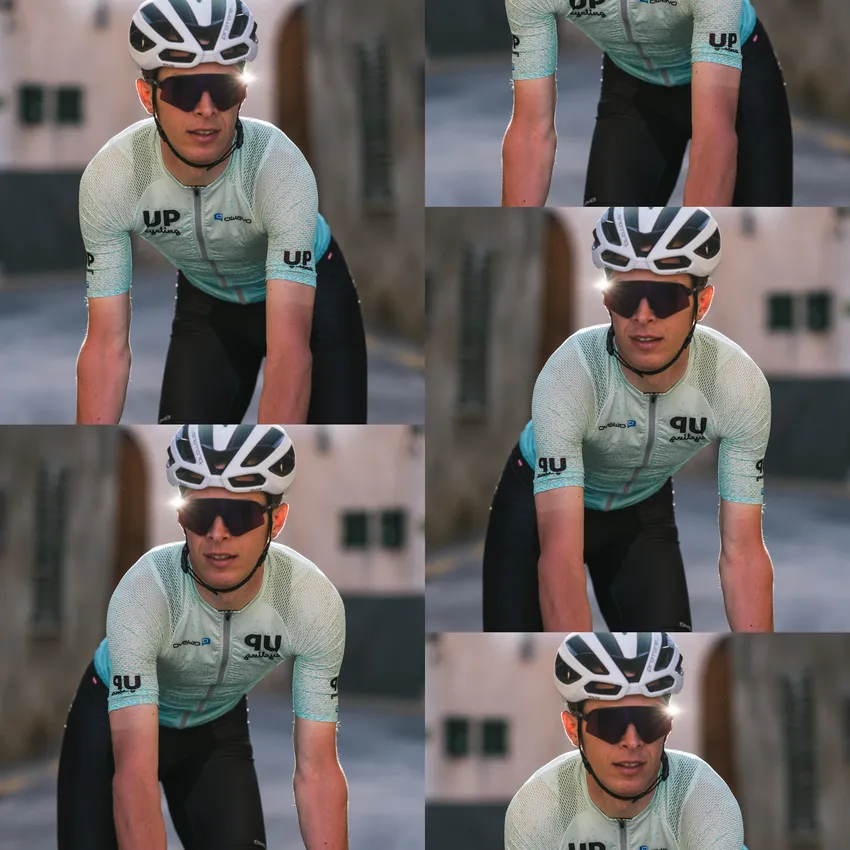 Een fietser in een lichtblauw shirt met korte mouwen en een zwarte broek rijdt op een zonnige straat.